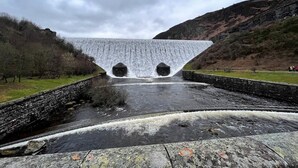 Une cascade avec une structure en pierre au premier plan.