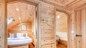 Ein Holzinterieur mit einem Bett, einem kleinen Tisch und einem Kleiderschrank.