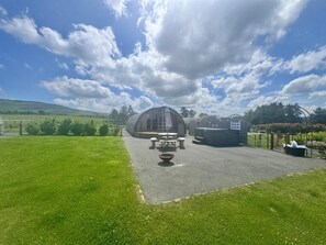 A greenhouse with a table and chairs, a hot tub, and a fenced garden area. - 2 Bed in Rhayader (oc-90279) (Saint Harmon)