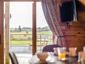 A wooden interior with a view of a grassy field and a picnic table outside. - 2 Bed in Rhayader (oc-90279) (Saint Harmon)