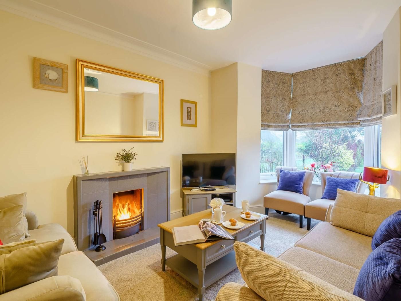 A living room with a fireplace, a sofa, a coffee table, and a television.