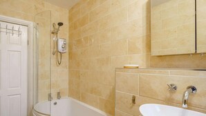 Ein Badezimmer mit Badewanne, Waschbecken und Dusche.