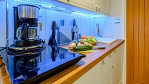 Eine Küche mit Kaffeemaschine, Obstschale und einem Messer auf der Arbeitsfläche.