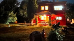 A two-story house with a visible front porch and a well-lit entrance.