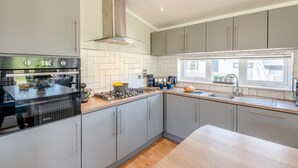 Eine moderne Küche mit grauen Schränken, einem eingebauten Backofen und einem Fenster für natürliches Licht.