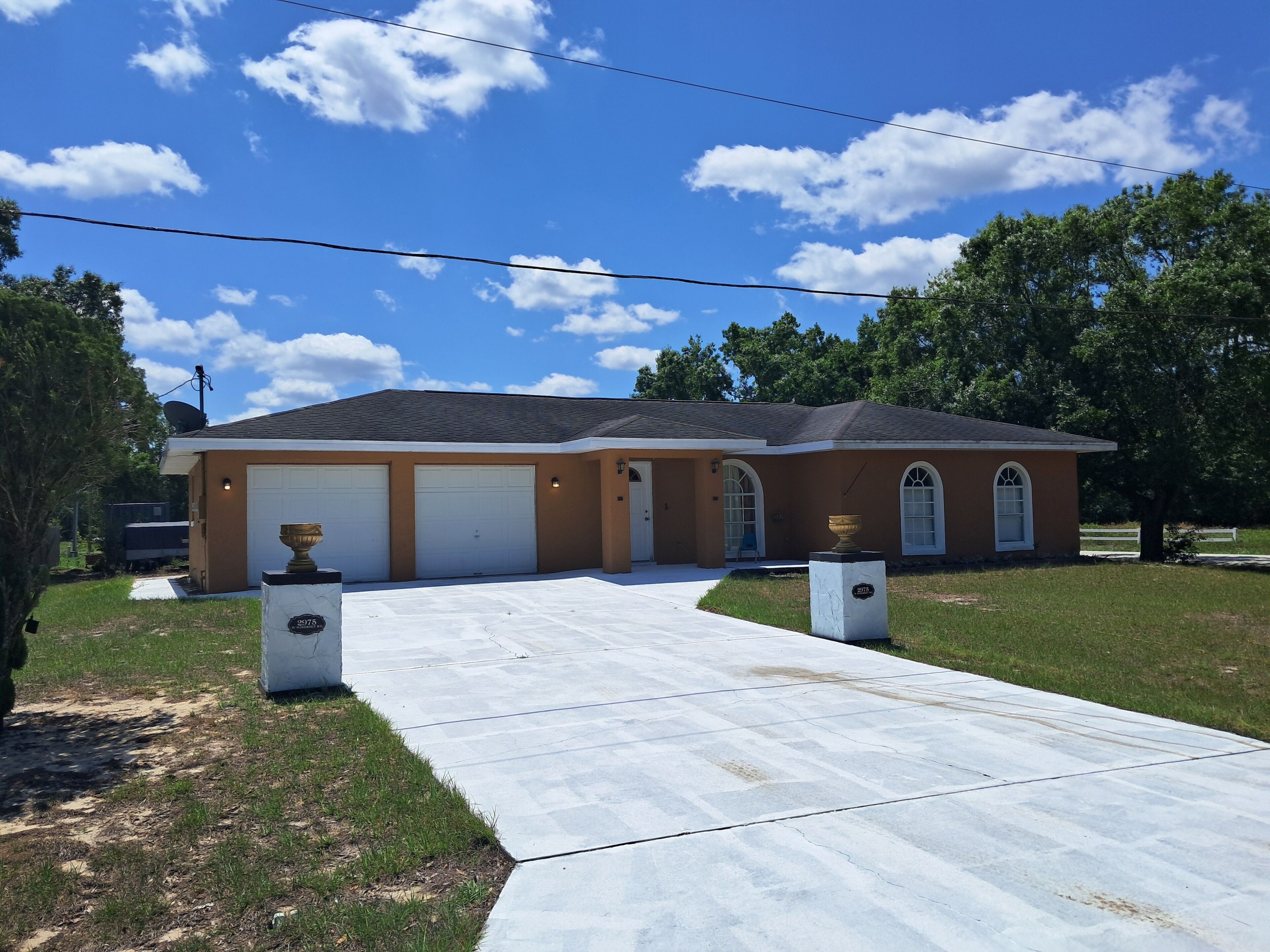 A two-story house with a garage, a driveway, and a lawn.