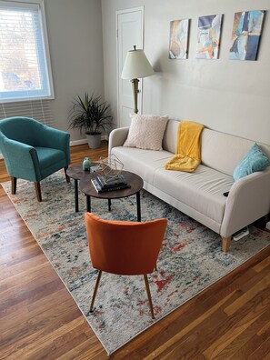 A living room with a sofa, two chairs, a coffee table, a lamp, and artwork on the wall. - Cozy 2BR Apartment with Easy Access to DC Attractions (Washington)