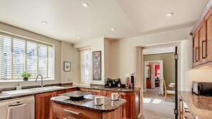 Een moderne keuken met een centraal eiland, roestvrijstalen apparatuur en houten kastjes.