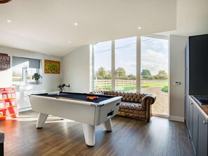 A pool table in a room with large windows, a sofa, and a view of an outdoor area. - 4 Bed in Axbridge (oc-90365) (Biddisham)