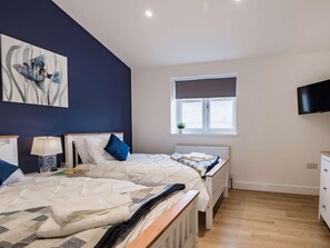 A bedroom with two beds, a window with a view, a TV, and a painting on the wall. - 4 Bed in Axbridge (oc-90365) (Biddisham)