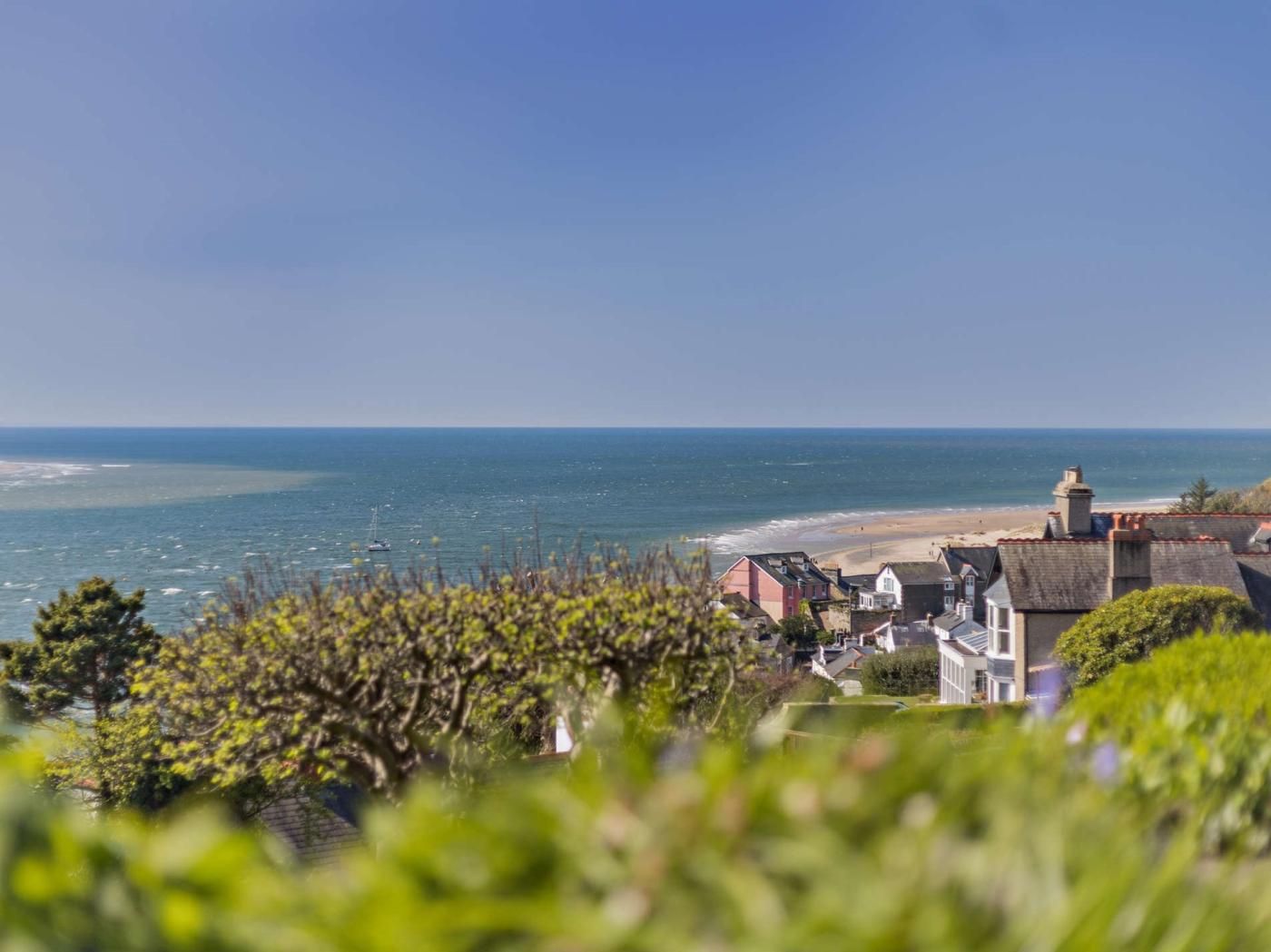 A coastal view with a beach, ocean, and residential buildings.