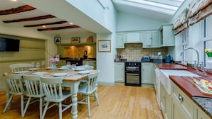 A kitchen with a dining area, wooden floors, and a skylight. - 4 Bed in Hexham (oc-90521) (Bardon Mill)