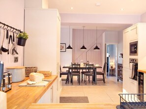 A modern kitchen with a wooden countertop, a dining area with a table and chairs, and a built-in oven. - 3 Bed in Bakewell (oc-90384) (Bakewell)