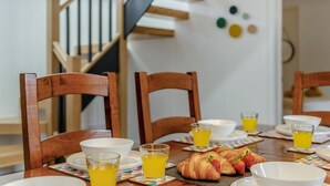 Ein Esstisch mit Stühlen, Tellern, Gläsern und Croissants.
