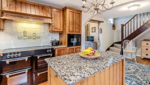 A kitchen with wooden cabinets, a granite countertop, a stove, and a chandelier. - 3 Bed in Lincoln (oc-90396) (Washingborough)