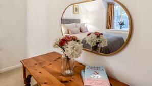 A bedroom with a bed, a bedside table with a book, a mirror, and a window with curtains. - 3 Bed in Lincoln (oc-90396) (Washingborough)