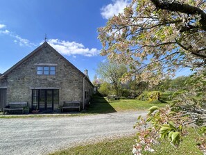 A stone building with a triangular roof, a window, and a door.
