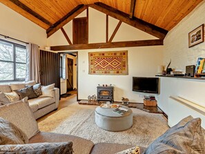 A cozy living room with a fireplace, a television, and a sofa. - 2 Bed in Dulverton (oc-90558) (Dulverton)