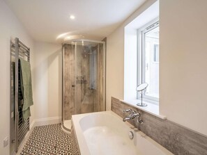 Une salle de bain avec une douche, une baignoire et une fenêtre.