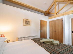 A bedroom with a bed, a radiator, wooden doors, and a framed picture on the wall. - 1 Bed in Carnforth (oc-90554) (Middleton)