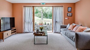 Ein Wohnzimmer mit Fernseher, Sofa und Couchtisch mit Tablett.