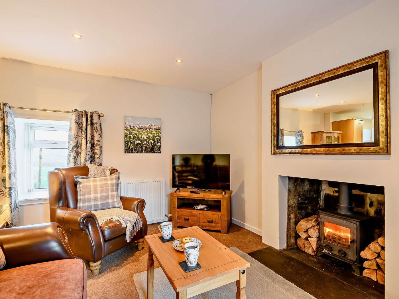 Una sala de estar acogedora con chimenea, televisor y un espacio de descanso cómodo.