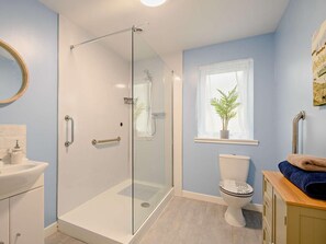 A bathroom with a glass-enclosed shower, a toilet, a sink, and a window with a plant. - 2 Bed in Bonnybridge (oc-90602) (Bonnybridge)