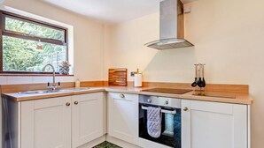 Une cuisine avec une fenêtre, une cuisinière et un évier.