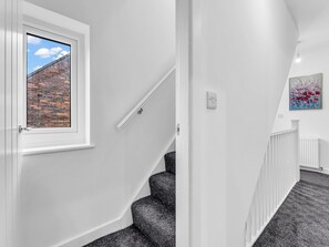 A staircase with a handrail, a window with a view of a brick wall, and a painting on the wall. - Family lux home/6-car drv/ pool table/projector/ (Chadderton)