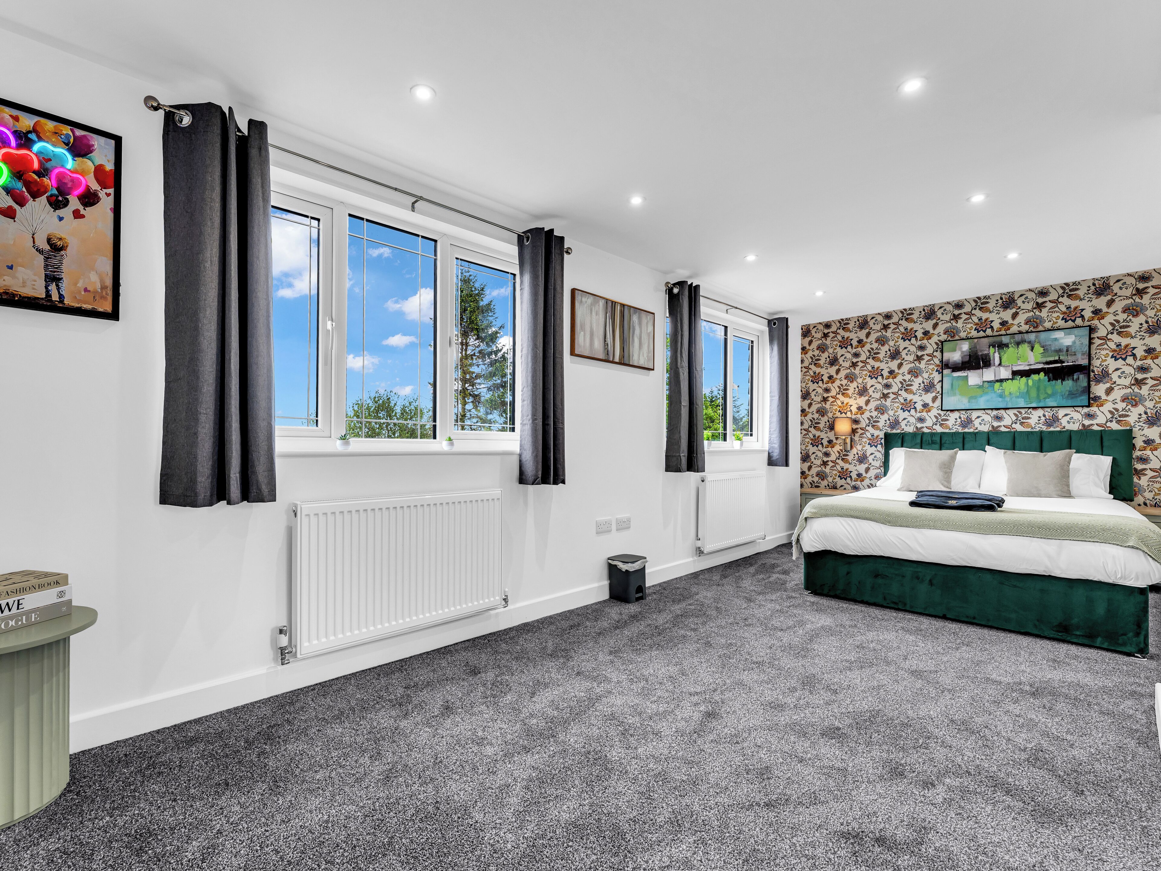 Bright, spacious king bedroom with large windows and stylish accent wall