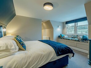 A bedroom with a bed, a window seat, and a radiator. - 4 Bed in Crieff (oc-90801) (Crieff)
