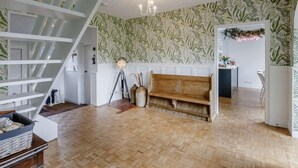 A spacious room with a wooden bench, a white staircase, and a wall with a leafy pattern. - 3 Bed in Malvern (oc-90775) (Mathon)
