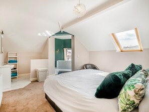 Una camera da letto con un letto, una sedia, una scrivania, una finestra e vista sull'esterno.