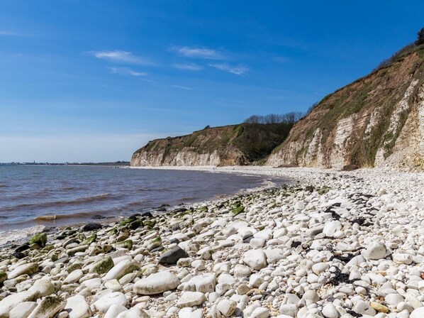 Una spiaggia di ciottoli con rocce bianche e scogliere.