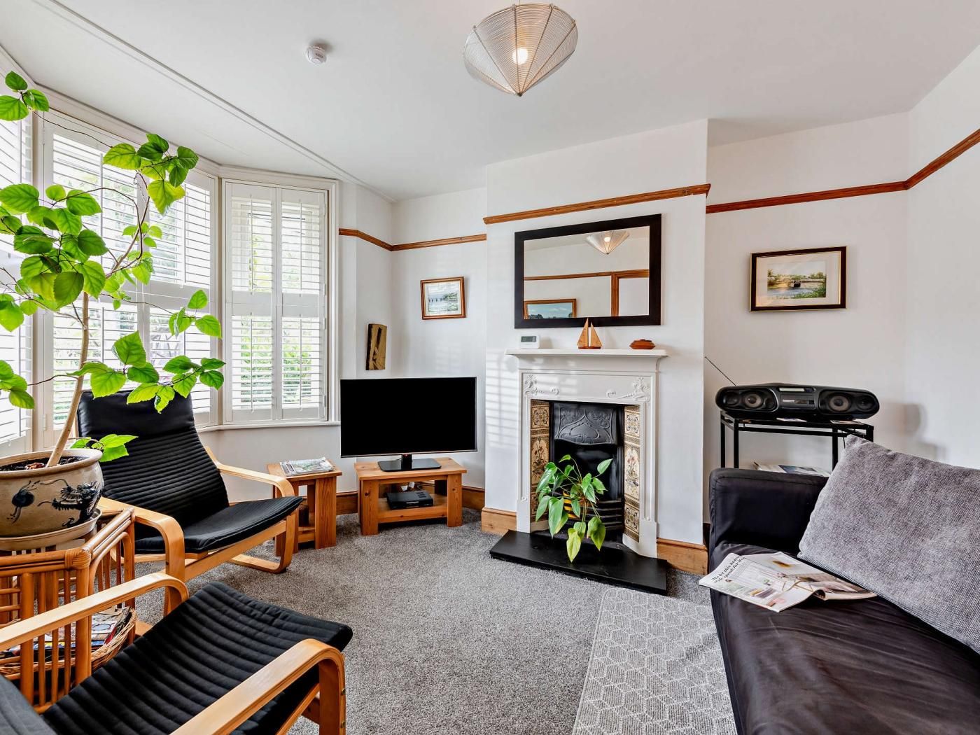 A living room with a fireplace, a television, and seating arrangements.