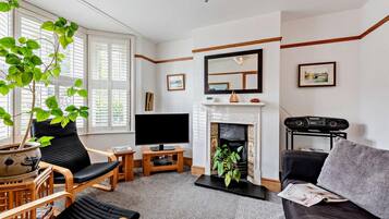 A living room with a fireplace, a television, and seating arrangements.