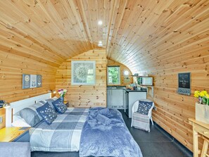 A cozy cabin interior with a bed, a small kitchenette, and a welcome sign. - 1 Bed in Church Stretton (oc-90929) (All Stretton)