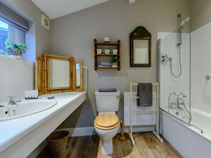 Ein Badezimmer mit Toilette, Waschbecken, Dusche und zwei Spiegeln.