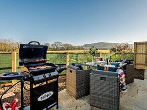 An outdoor patio with a barbecue grill, wicker furniture, and a view of the countryside. - 2 Bed in Shaftesbury (oc-91172) (Motcombe)