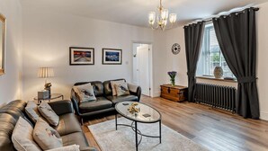 A living room with a sofa, coffee table, and artwork on the wall. - 2 Bed in Morpeth (oc-91206) (Amble)