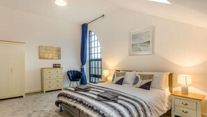 A bedroom with a bed, nightstands, a wardrobe, a chair, and a window with curtains. - 3 Bed in Rye- (oc-90766) (Rye)