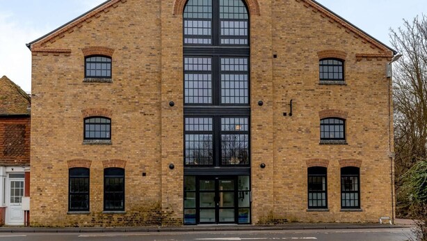 A brick building with a large central arched window, multiple smaller windows, and a flat roof. - 3 Bed in Rye- (oc-90766) (Rye)