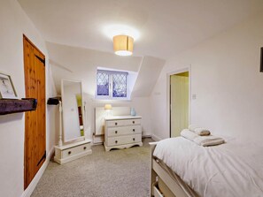 A bedroom with a bed, dresser, radiator, and a window with a view. - 3 Bed in Holt (oc-90943) (Weybourne)