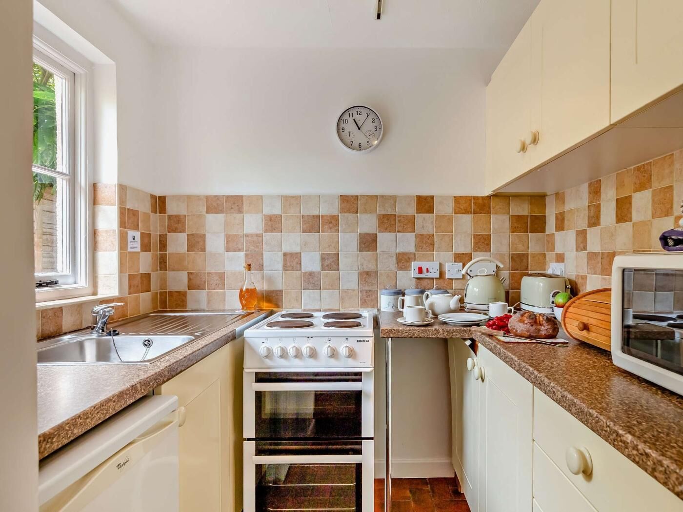 Une cuisine équipée d’une cuisinière, d’un four, d’un évier et d’un four à micro-ondes.