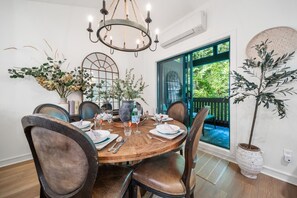 A dining area with a round table, chairs, and a chandelier. - Near Gondola & Lake | Private Hot Tub| Free Ski Shuttle & Parking (Whistler)