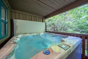 A hot tub with a control panel, surrounded by wooden walls and a view of a forest. - Near Gondola & Lake | Private Hot Tub| Free Ski Shuttle & Parking (Whistler)