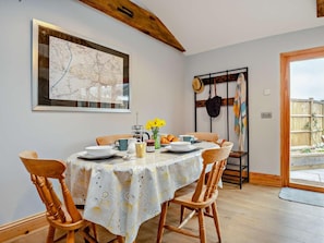 A dining area with a round table, chairs, and a map on the wall. - 2 Bed in Axbridge (oc-91358) (Compton Bishop)