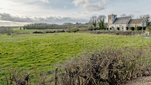 Un paisaje rural con una iglesia y campos abiertos.