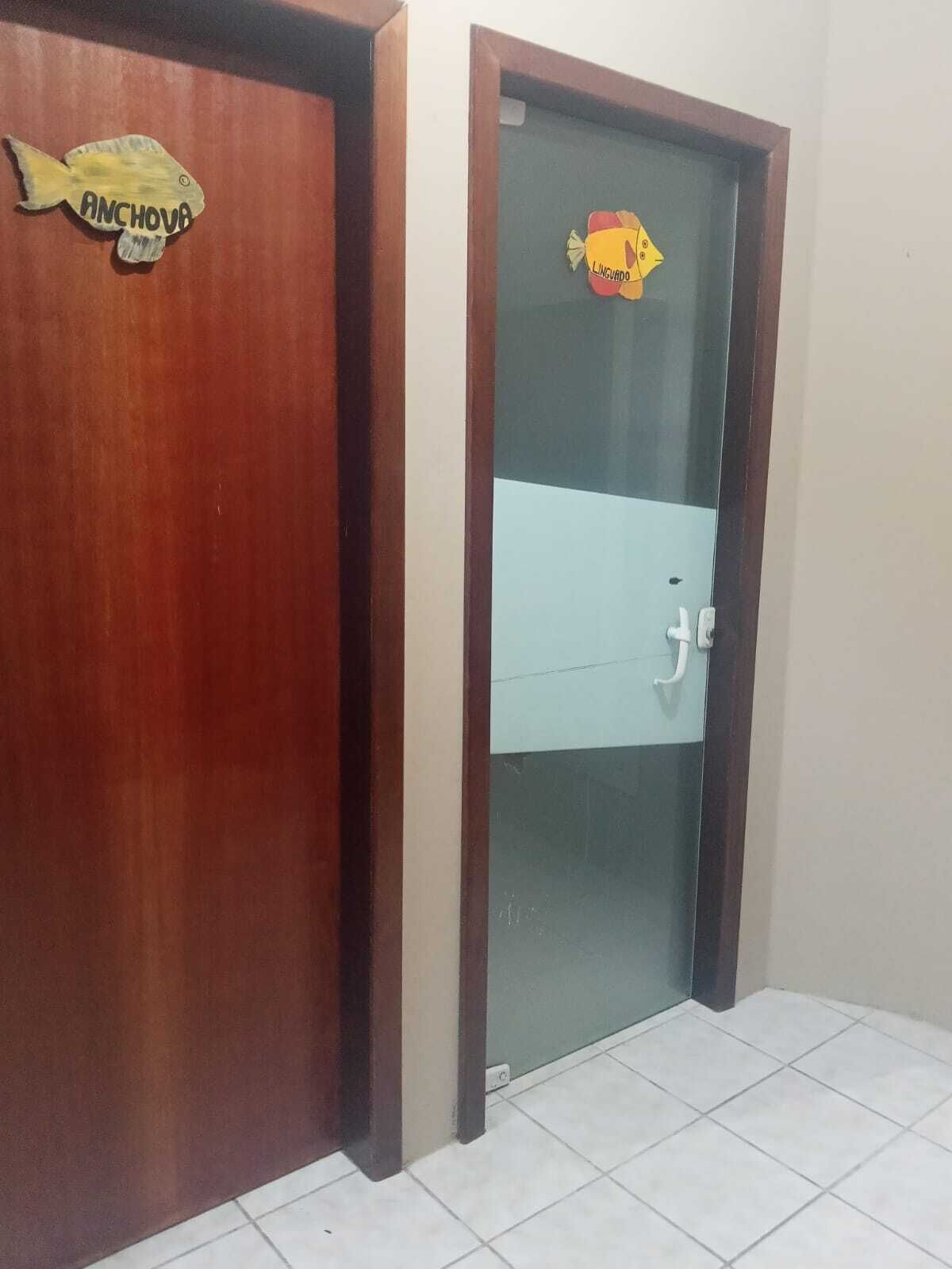 Uma porta de madeira com um adesivo de peixe e uma porta de vidro com um adesivo de peixe.
