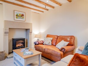 A cozy living room with a fireplace, a leather sofa, and a wooden coffee table. - 2 Bed in Matlock (oc-91398) (Wirksworth)